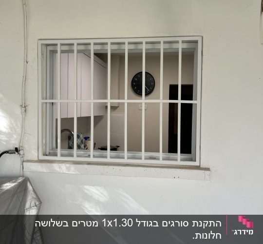 חלון עם סורגים לבנים על קיר חיצוני